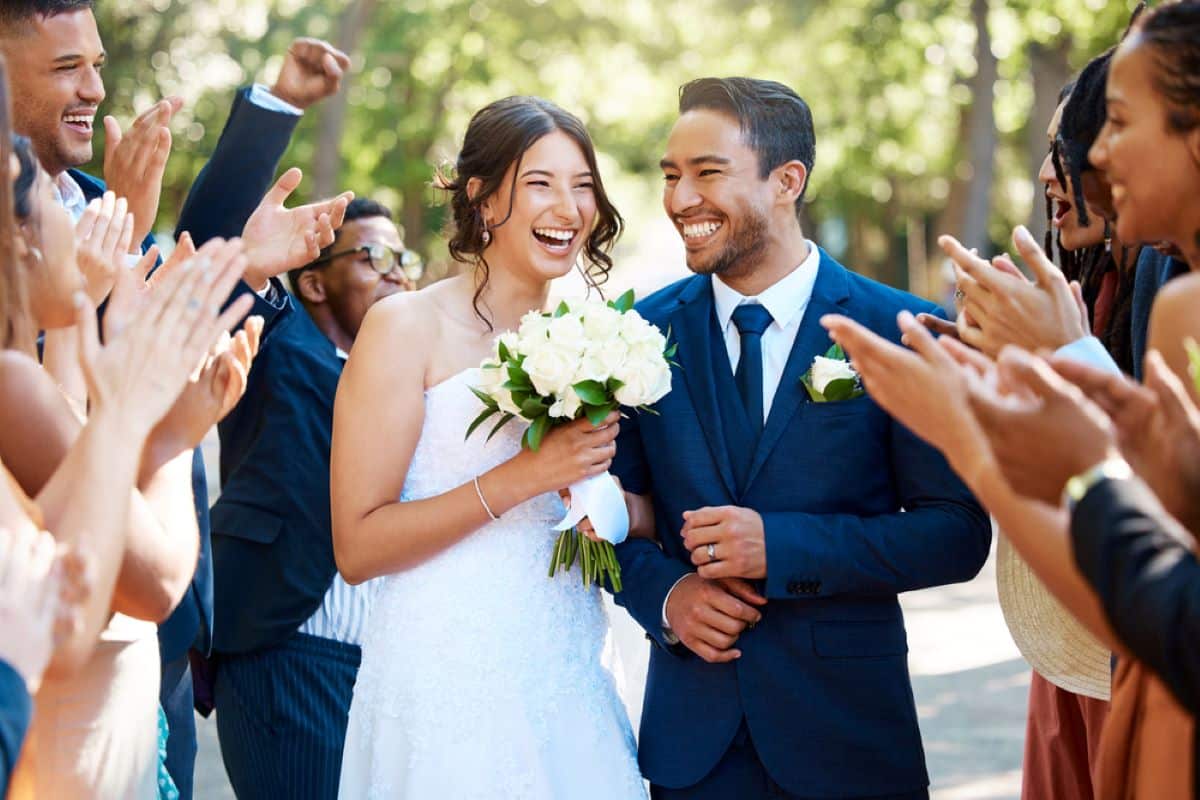 Couple heureux qui celebre leur mariage avec des invites a la ceremonie