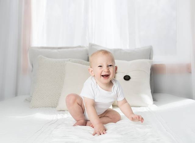 un beau bébé enfant joyeux sur son lit