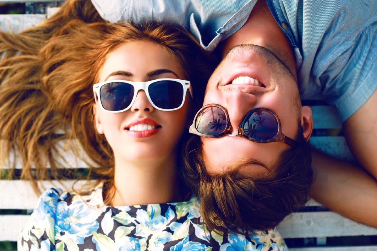 Un homme et une femme heureux qui portent des lunettes de soleil pas cheres