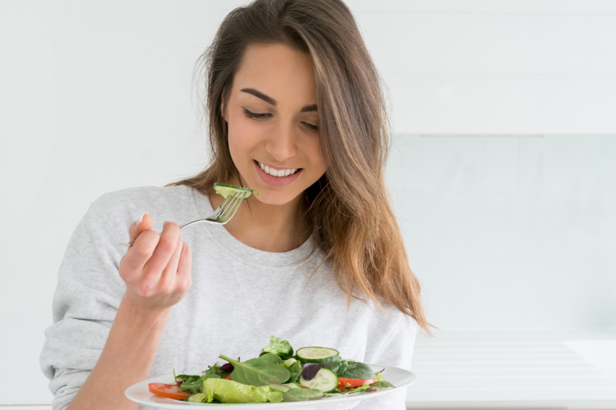 une femme mangeant une assiette équilibrée