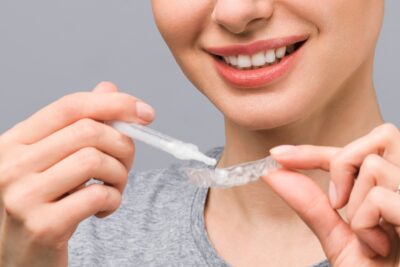 une femme utilise un kit de blanchiment dentaire