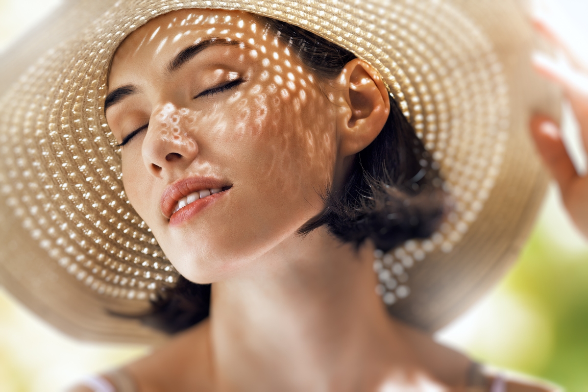 belle femme avec un chapeau en été peau éclatante et protégée