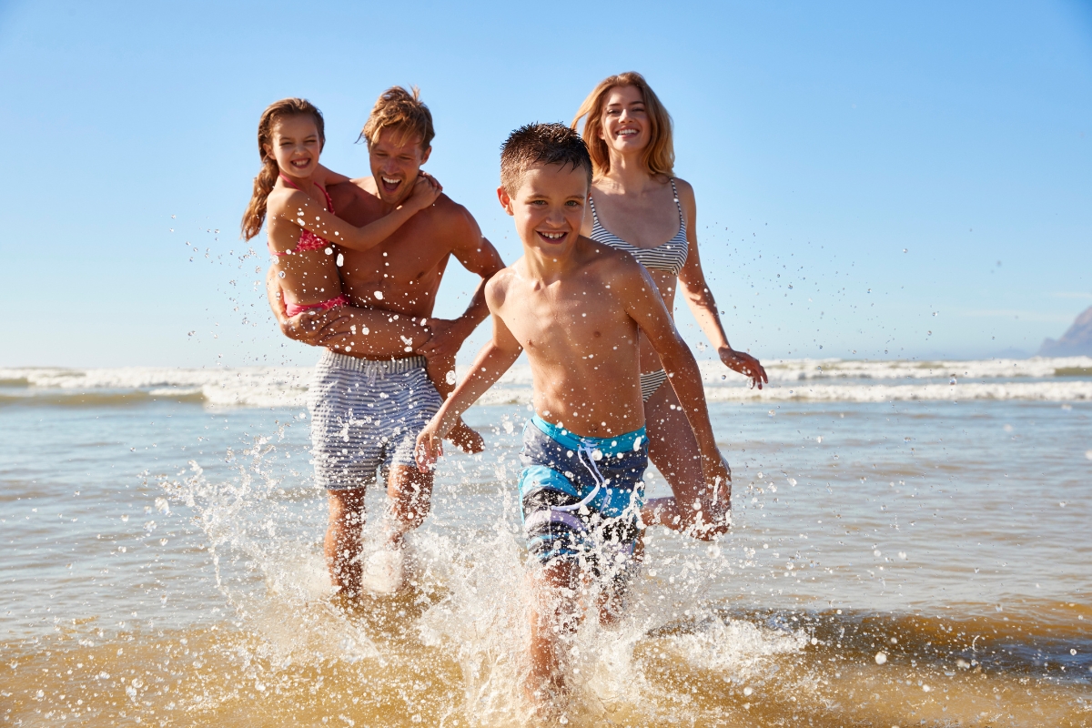 une famille joue au bord de l'eau sur la plage, activités, moments de joie