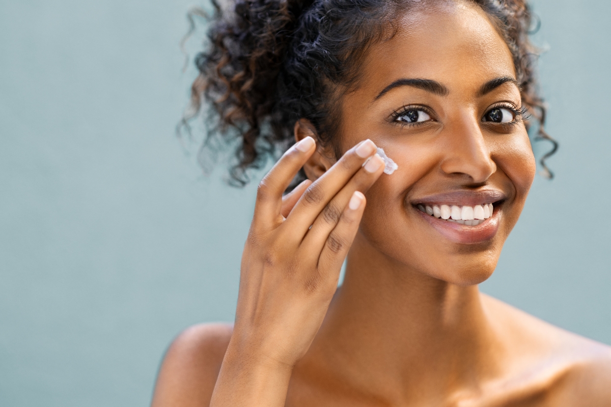 une belle femme noire qui hydrate sa peau