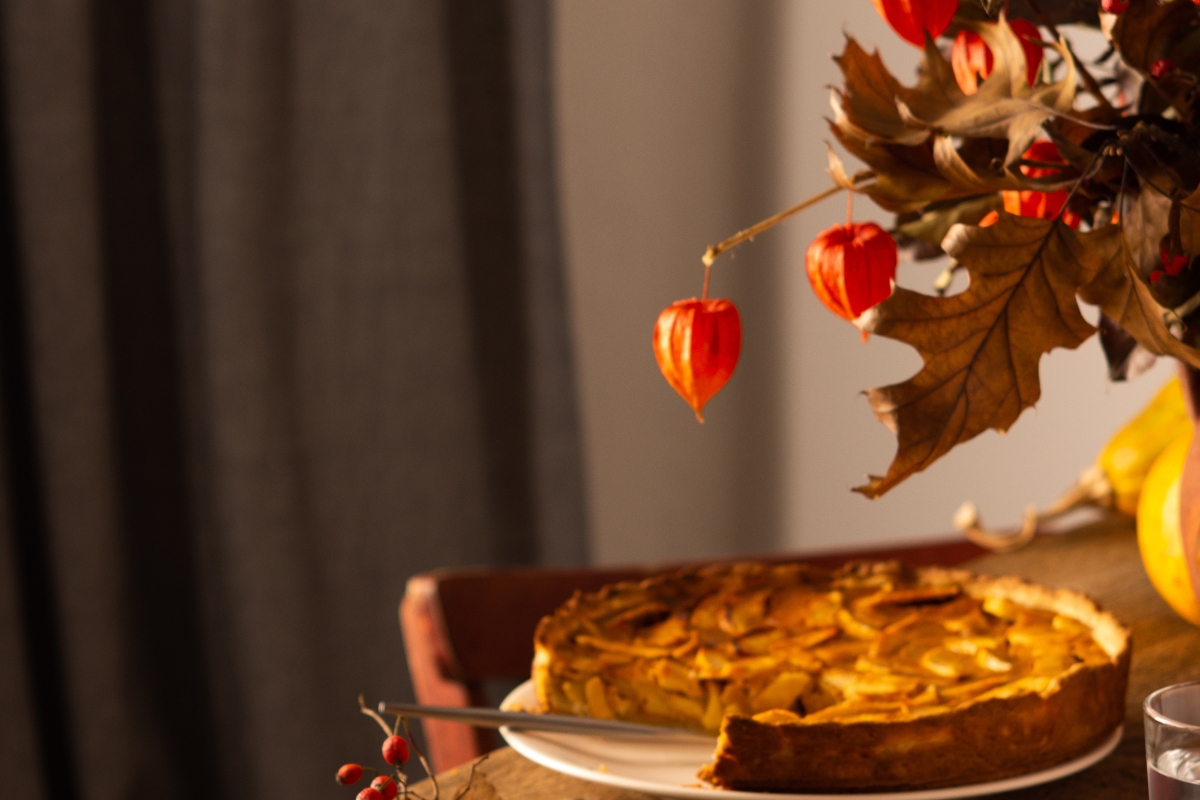 une magnifique tarte au pomme caramélisée, sur une table avec un beau décor automnal