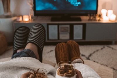 Couple chaussons et couvertures sur un lit, cocooning soirée netflix