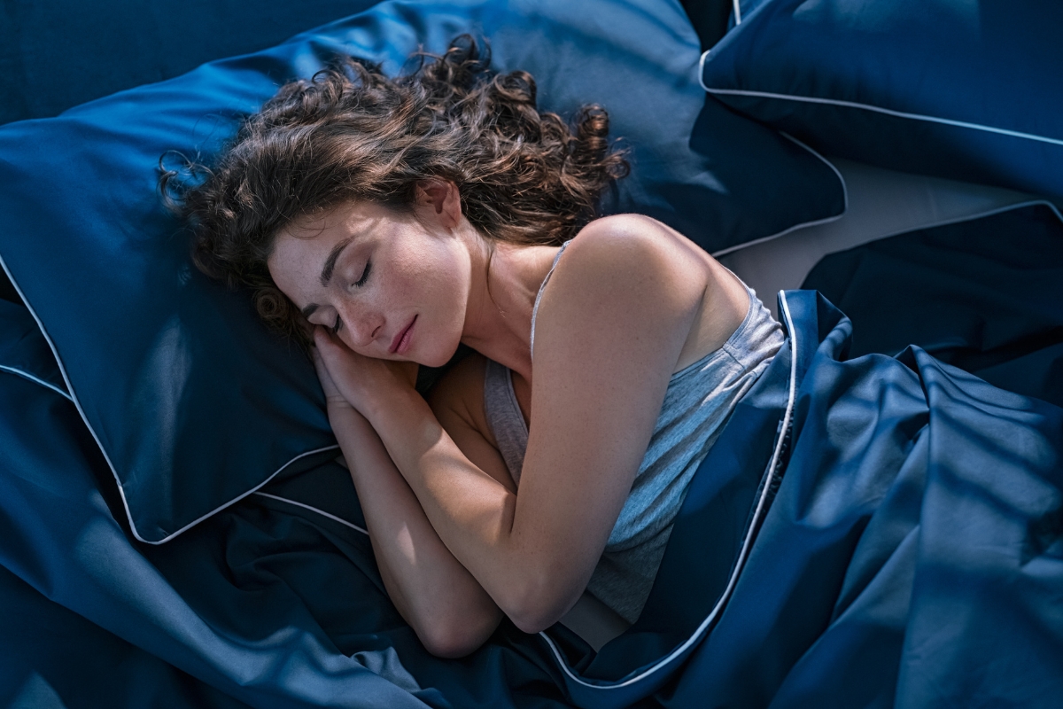 une femme qui dort dans un linge de lit de qualité bleu royal