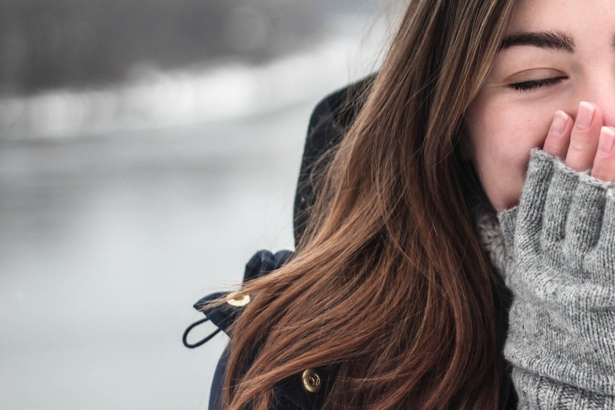 une femme heureuse en hiver grace a ses vetements chauds