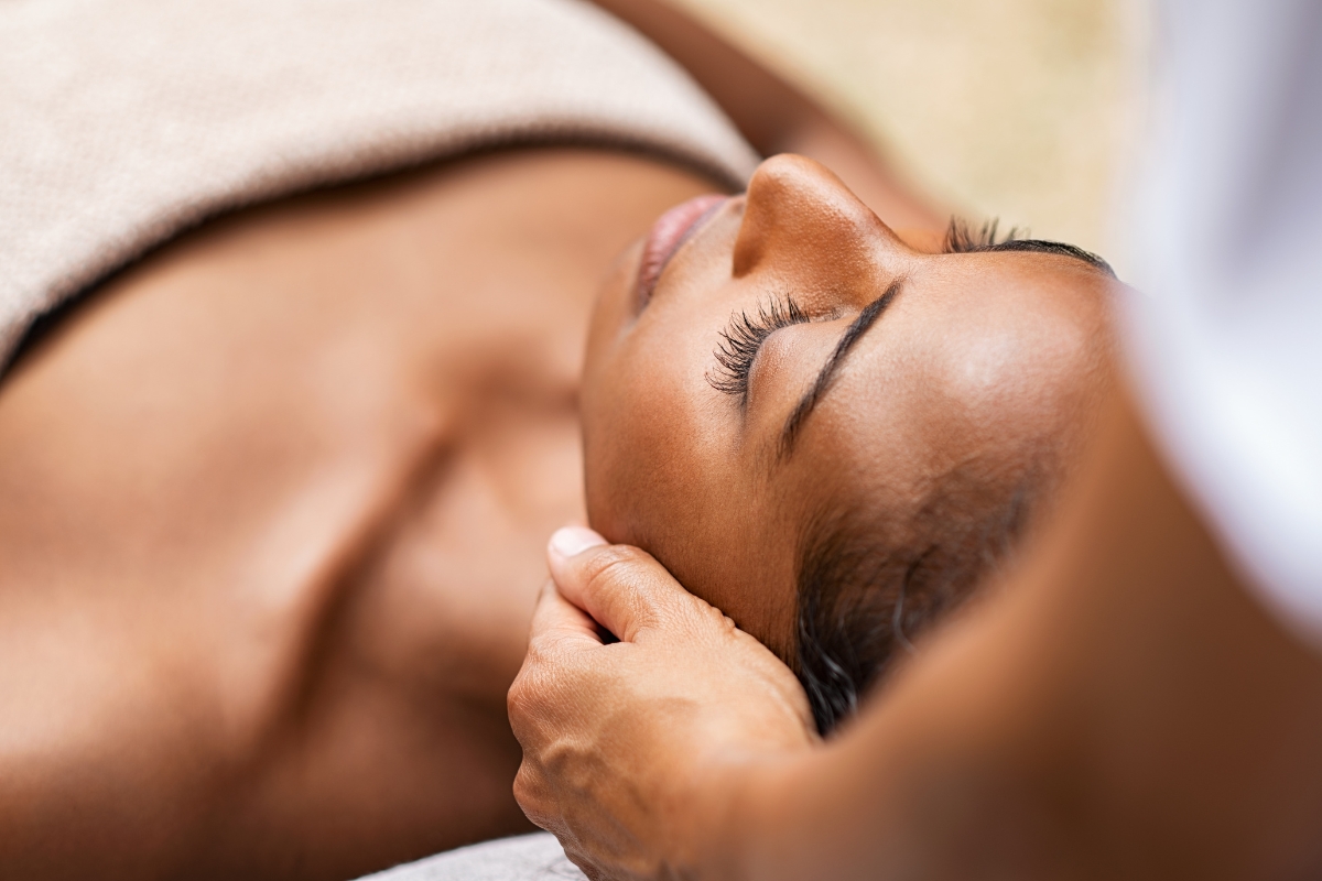 belle femme noire se fait masser le visage pendant sa cure bien être