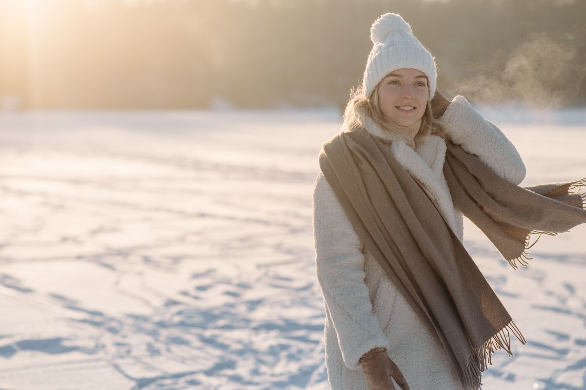 une femme avec des vetements chauds bonnets gants echarpe manteaux dans la neige