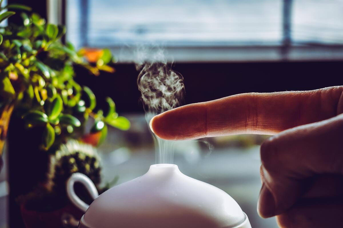 un doigt qui touche l'air humidifié d'un humidificateur d'air