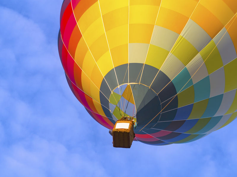 Une montgolfiere multicolore vue du bas qui senvole dans le ciel