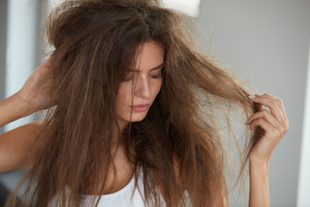 une femme aux cheveux raides et secs, triste préoccupée, avec un soucis d'hydratation