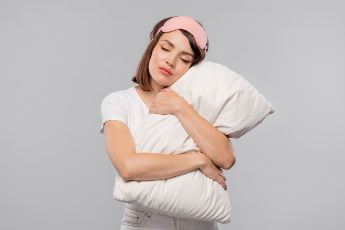 une femme fatiguee qui fait un calin a un oreiller qu'elle vient de choisir