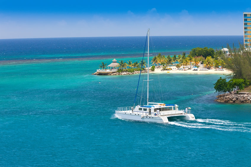 Magifique decor de carte postale bateau sur une mer bleue palmiers et complexe touristique