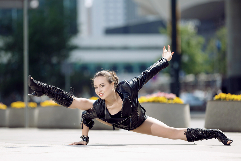 femme qui danse dehors en street avec une posture acrobatique grand écart avec des heels