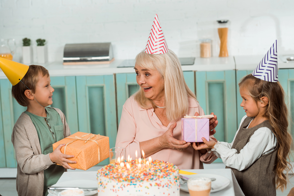 fete grand mere célébrée à la maison avec petits enfants et un gros bon gateau