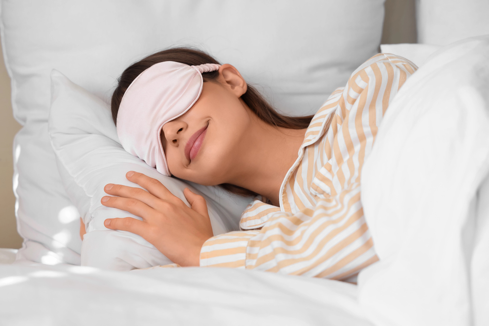 femme brune avec un bandeau sur les yeux passant une bonne nuit de sommeil