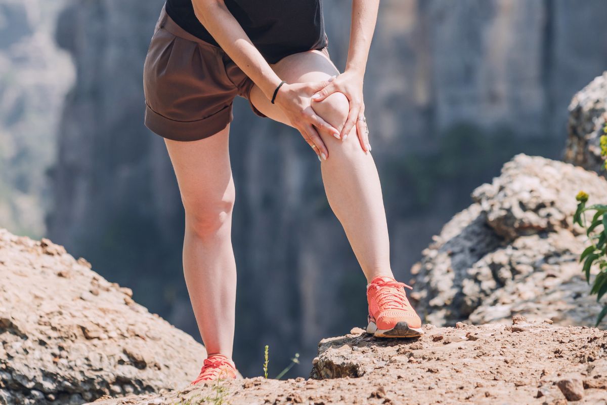 une femme qui tient son genou avec ses mains car elle a mal a ses articulations